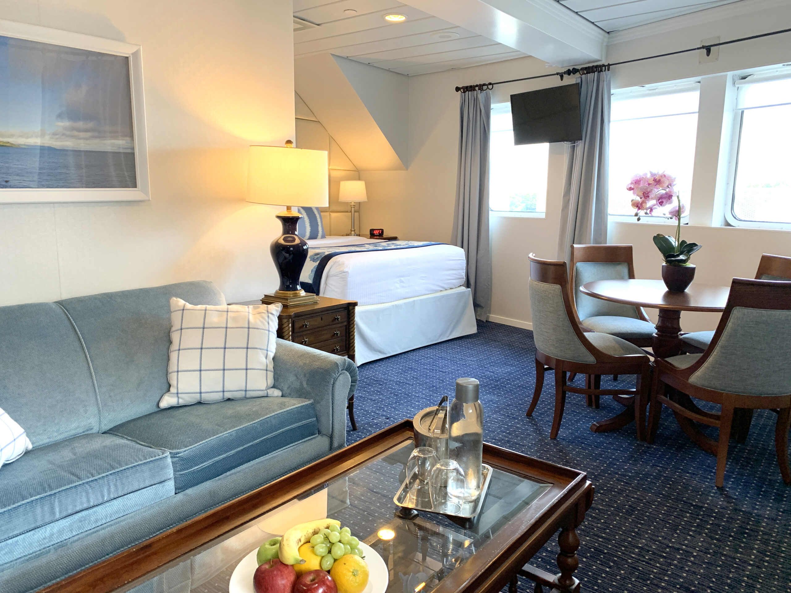 The Victory 1 stateroom featuring a comfortable bed and a cozy living area, elegantly furnished with tasteful decor.