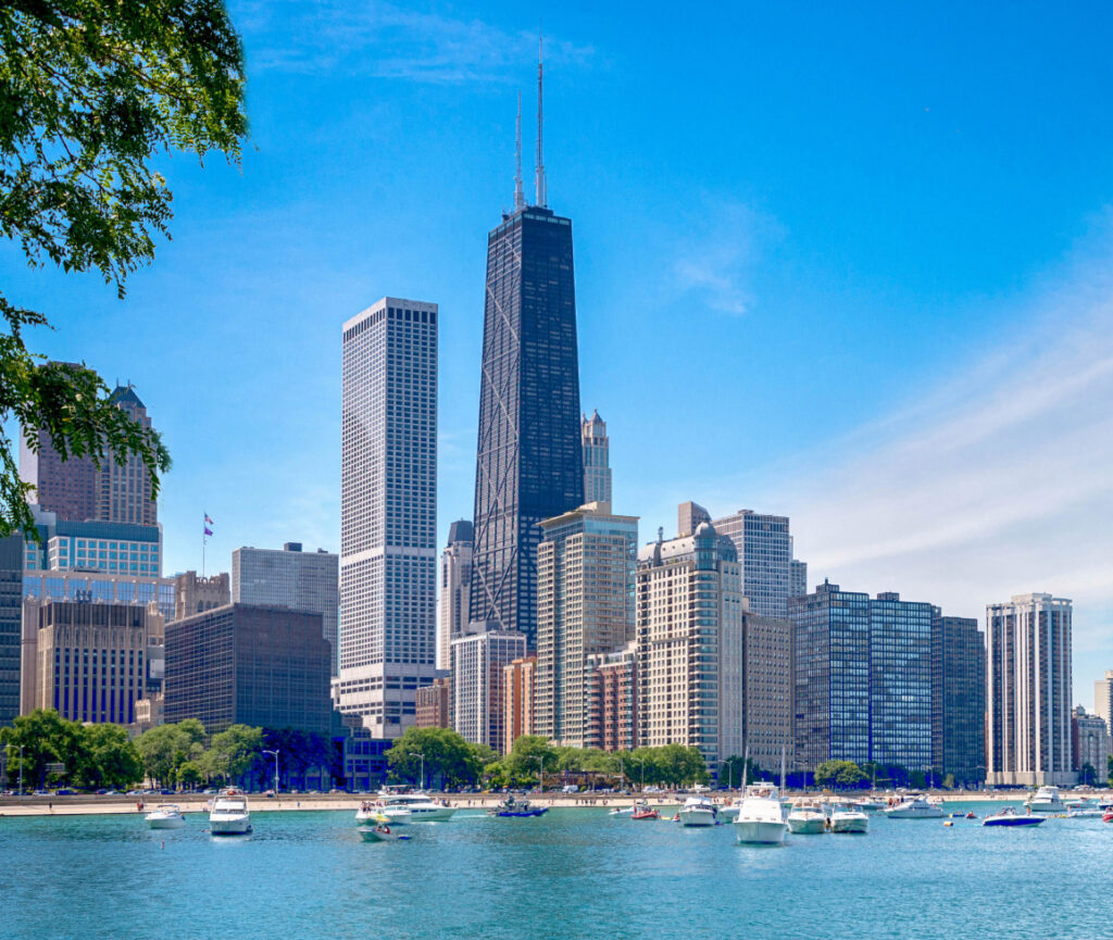 A view of Willis Tower in Chicago, showcasing its towering, sleek black structure against a clear blue sky.