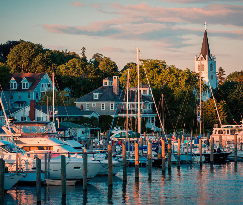 A picturesque view of Mackinac Island Harbor, featuring sailboats and yachts docked along the marina.