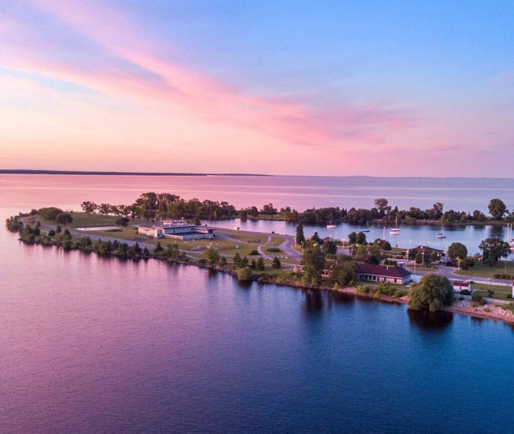 A stunning sunset in Escanaba, Michigan, with the sky painted in vibrant shades of orange, pink, and purple.