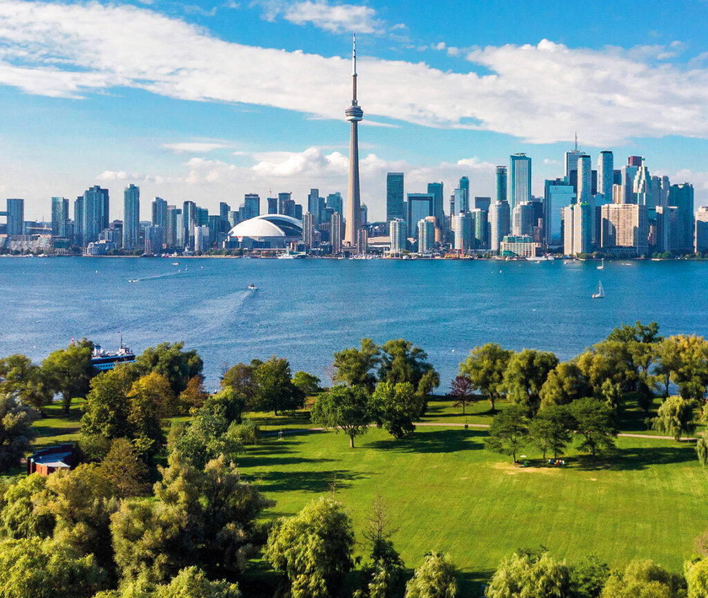 A panoramic view of the Toronto skyline, featuring the iconic CN Tower and modern skyscrapers.